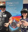 Two workshop participants wearing mixed reality headsets hold VR controllers while taking part in an interactive demonstration in front of CoSTAR Screen Lab branding.